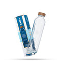 Botella de cristal inclinada frente a su caja azul de la colección energy flow.